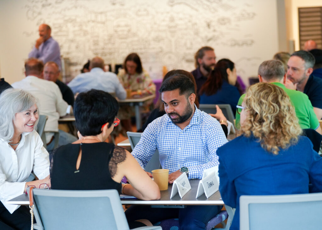 Several diverse adults are discussing around a table.